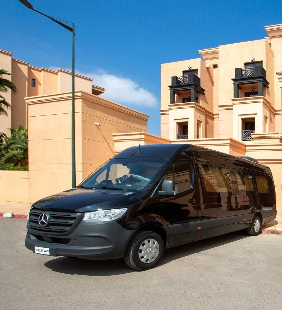 Minibús Mercedes-Benz negro junto a un edificio de tonos ocres en Marruecos